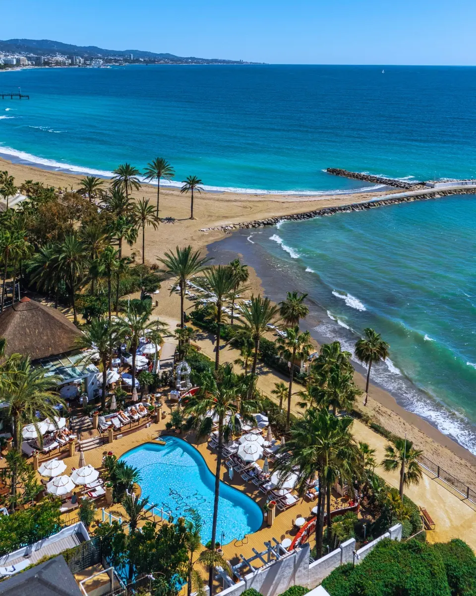 Aerial view of Puente Romano: palm gardens, the pool and the beach along Marbella’s Golden Mile