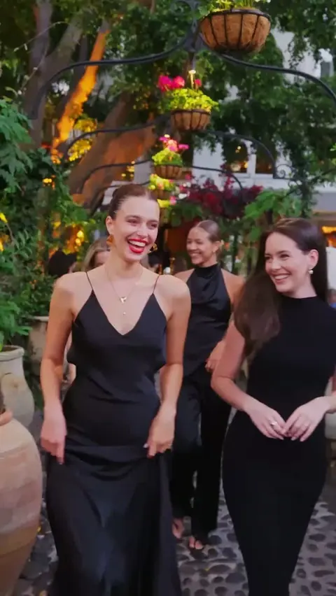 Three guests in black dresses arriving in the garden