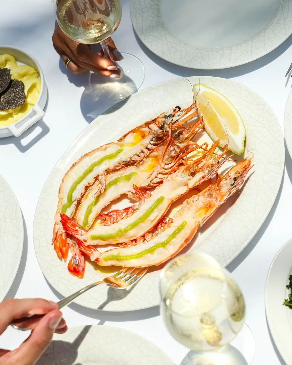 Grilled king prawns with lemon on a white plate