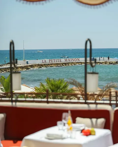 View from a terrace table to the sea wall painted with La Petite Maison